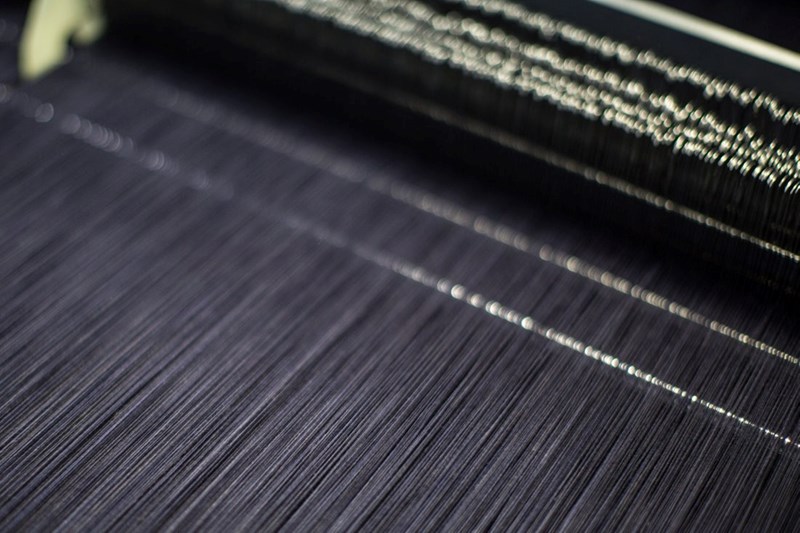 DENIM IS SEEN ON A WEAVING MACHINE AT THE MOMOTARY JEANS FACTORY