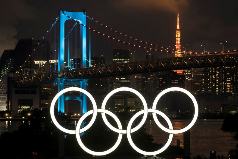 ILLUMINATED OLYMPIC RINGS ARE SEEN IN FRONT OF THE RAINBOW BRIDGE AND THE TOKYO TOWER AT NIGHT