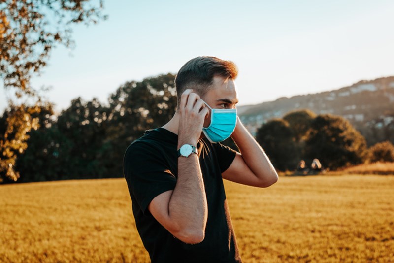 YOUNG MAN WITH PROTECTIVE MASK