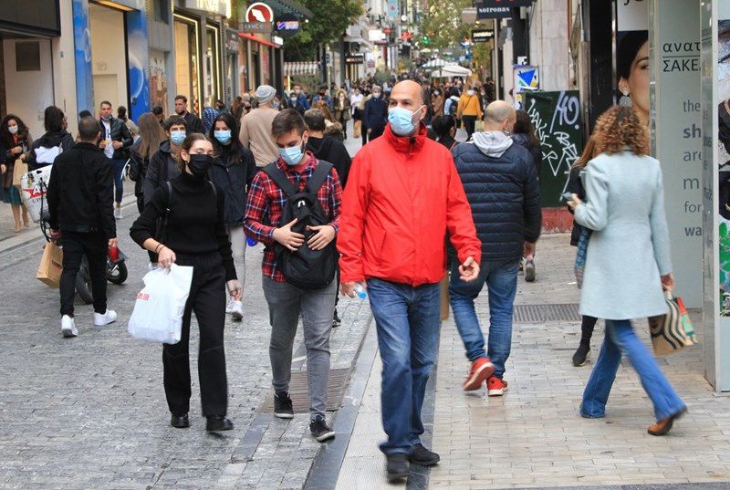 κόσμος περπατάει με μάσκες στην Ερμού