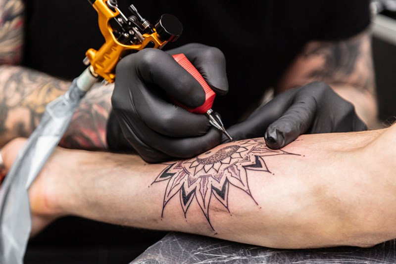 MAN HAVING A TATOO ON HIS ARM