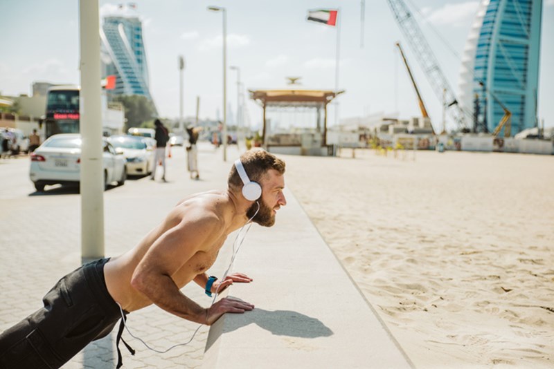 MAN WORKING OUT ON THE BEACH