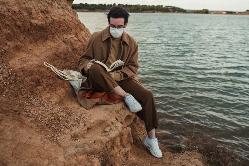 MAN READING A BOOK BY THE SEA