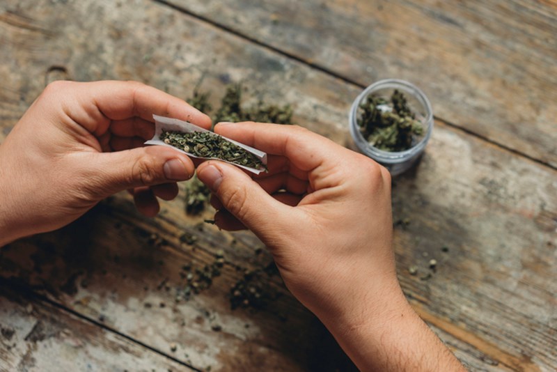 MAN ROLLING A MARIJUANA JOINT