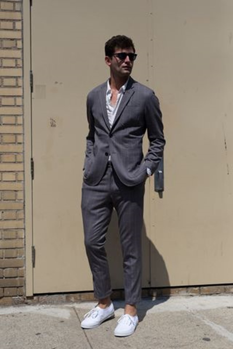 STYLISH MAN WEARING SNEAKERS UNDER HIS SUIT